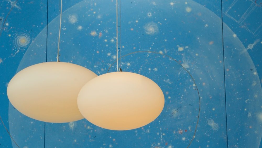 Vita ovala lampor mot blå bakgrund.